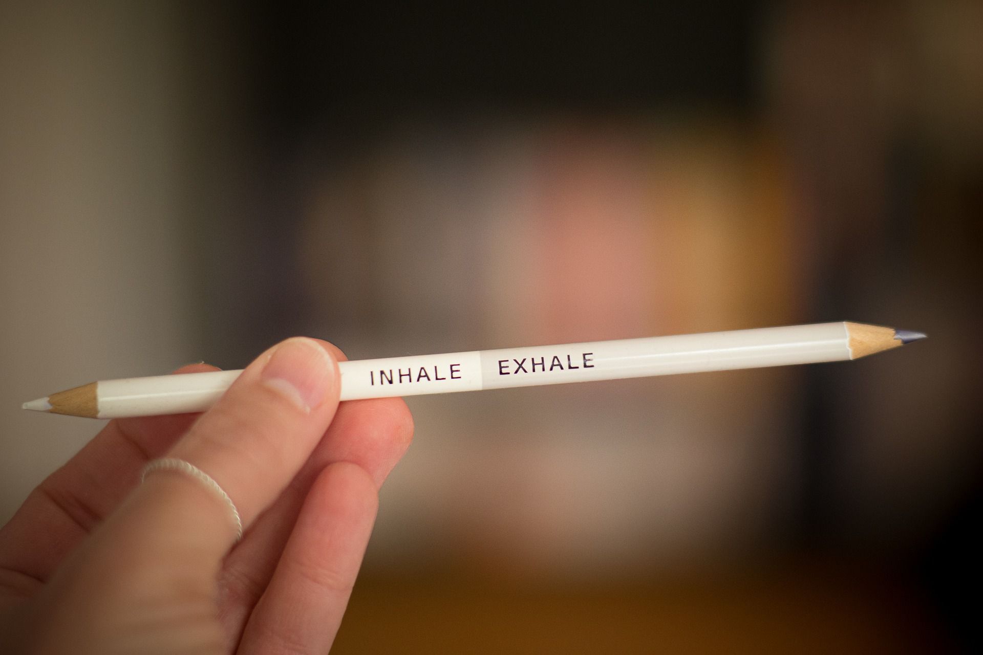 valkoinen kaksipäinen kynä, jonka varressa lukee englanniksi "hengitä sisään" ja "hengitä ulos"